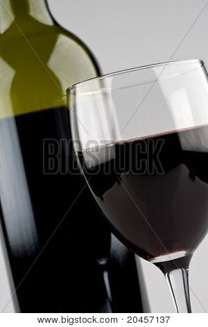 Glas of rode wijn met groene fles
