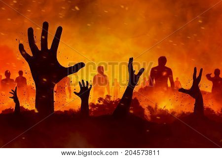 Halloween concept scary zombies hand silhouette on fire background