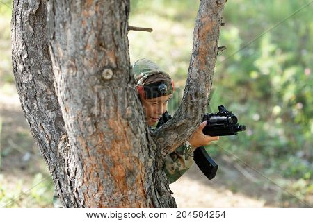 Child In Camouflage With A Gun Shoots, Laser Tag