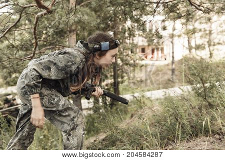 Young boy with a gun laser tag war simulation. Lasertag shooting game. Military sport