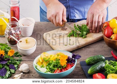 the man cooking a vegetarian salad on wooden table