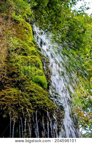 Photo of little beautiful waterfall flowing in cave