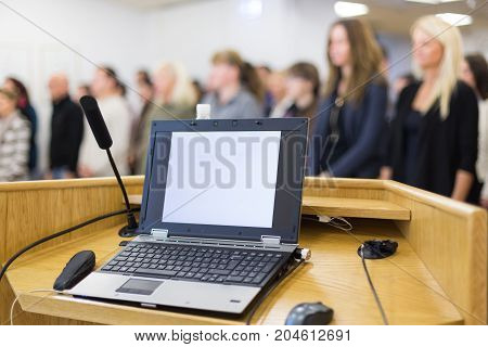 Laptop computer and microphotone at podium on business conference event. Business and entrepreneurship concept.