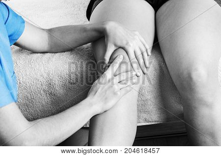 Physiotherapist chiropractor doing a patellar mobilization Knee pain in silhouette color and black and white.