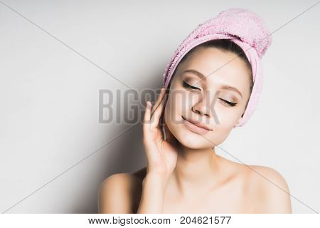 Beauty face woman touch her clean skin face. Girl in towel