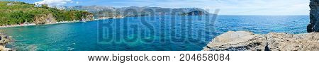 BUDVA MONTENEGRO - SEPTEMBER 7 2017: Beautiful panoramic view of Budva coast (Mogren beach Budva Old Town Sveti Nikola Island). Unknown people rest on beach of popular resort