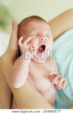Sleeping yawn little newborn girl. With mother