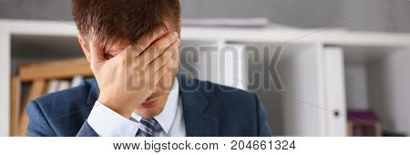 A Man Experiences Stress And A Headache In The Workplace