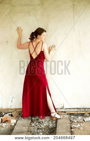 Young girl indoors. Red cute dress, leg