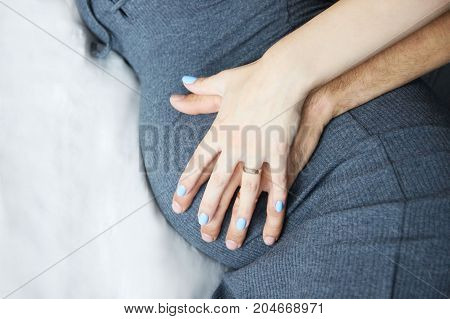 Pregnant girl. Gentle touch. Motherhood. Parents hands
