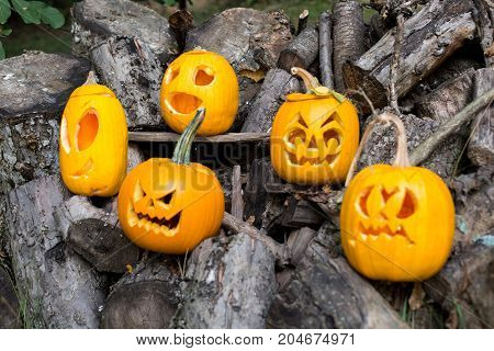 Halloween Themes. Composition Of Five Carved Halloween Pumpkins On Wooden Background. Pumpkins With