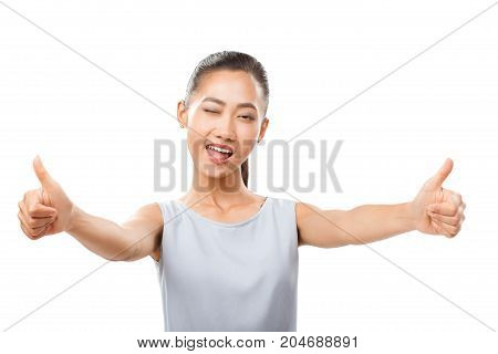 Asian Woman With Stretched Hands Showing Thumbs Up And Winking