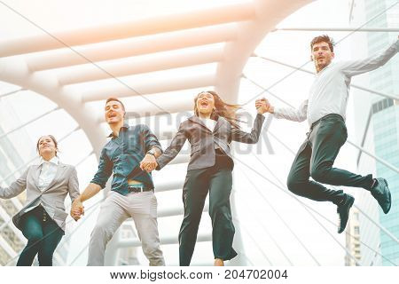 Successful business team shook hands together and jumping in the city Highly successful startup team concept of business and modern lifestyle.