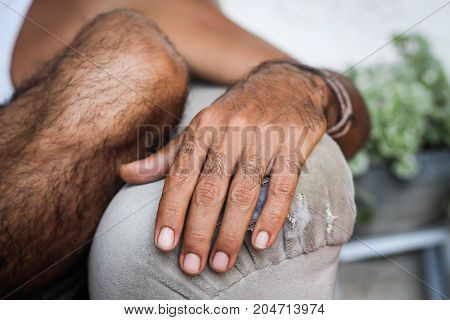 A man's hand laid on the couch handle very calmly