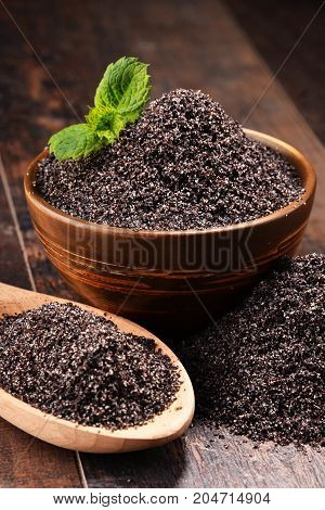 Composition With Bowl Of Poppy Seeds On Wooden Table