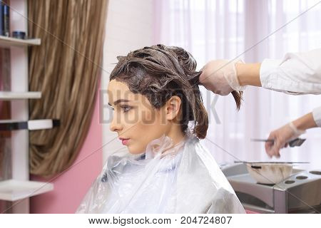 Hair dying side view. Female in beauty salon.