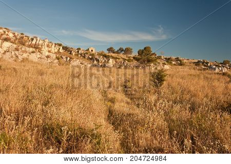 A typical spring landscape on a hill of Trapani a beautiful sicilian city with a rural farms house in the background