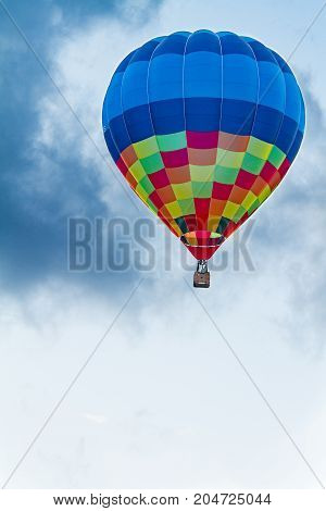Colored hot air balloon flying with clouds in the background