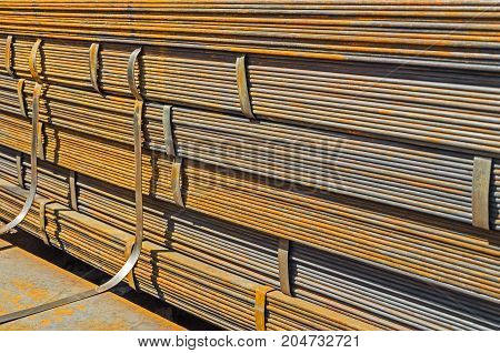 The rusty hot-rolled sheet metal in packs at the warehouse of metal products piled in the open air