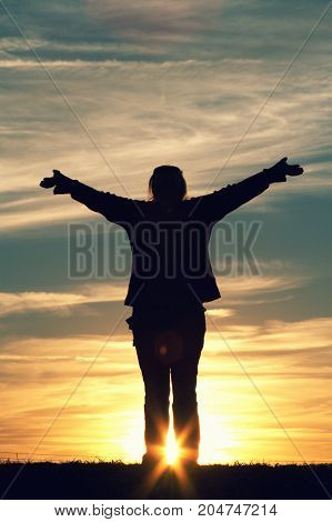 a woman with her arms raised in joy.