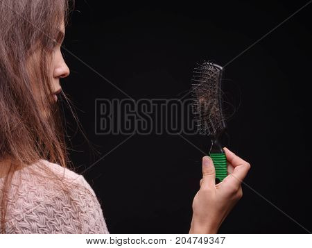 The problem of hair loss in women. Isolated on black background