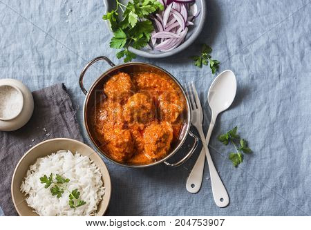 Chicken curry sauce meatballs and rice on a blue background top view. Indian food. Healthy food concept