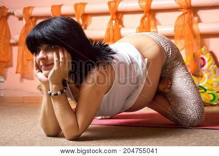 Pregnancy Yoga and Fitness concept. Healthy maternity lifestyle concept. 40 week pregnant middle aged caucasian woman sitting in lotus asana on the knees and arms doing yoga exercise.