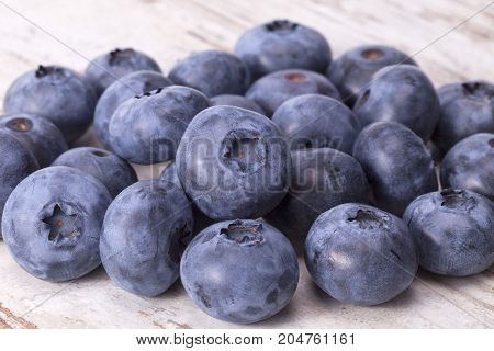Fruits of northern highbush blueberry (Vaccinium corymbosum) on a wooden board close up