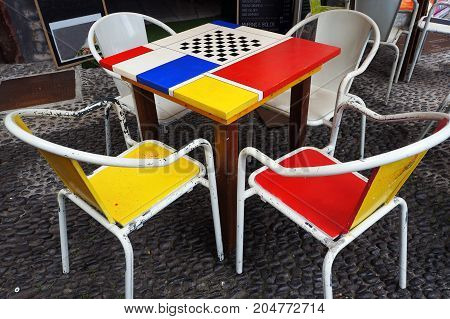 Tables and chairs of street cafe in Funchal Madeira.