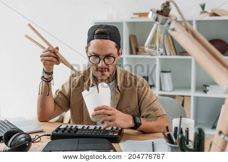 Musician Eating Chinese Food With Drumsticks