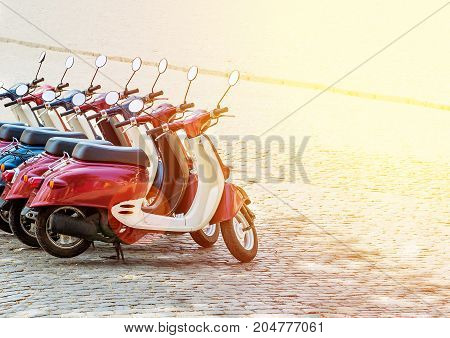 Colorful moped scooter parking. Transport wheel. Summer sunlight flare.