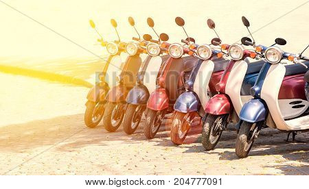 Colorful moped scooter parking. Transport wheel. Summer sunlight flare.