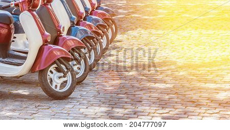 Colorful moped scooter parking. Transport wheel. Summer sunlight flare.