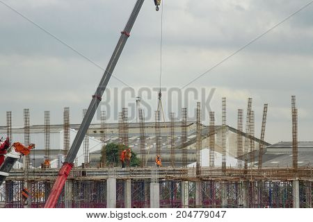 Workers are on building of factory and red crain.