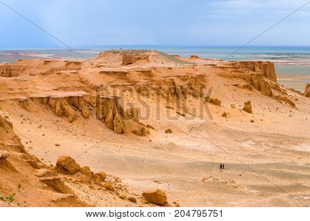 Distant tourists walking around Khermen Tsav the site of full dinosaur bones discovery in southern Mongolia