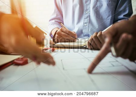 Consultation between colleagues engineering team to check the blueprint used to build commercial buildings for joint ventures.