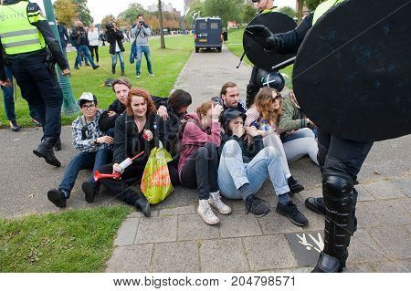 ENSCHEDE THE NETHERLANDS - SEPT 17 2017: Left wing protesters are blocking the road during an anti islam demonstration of Pegida. Pegida is a group of people who are against the islamization of Europe.