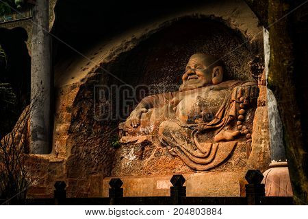 The Buddha statue in Leshan, China. The image of a man sitting in a lotus pose in a rock