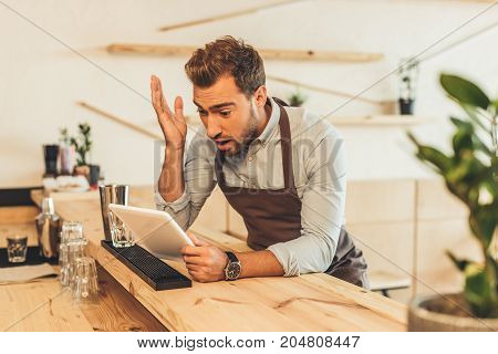 Barista Using Tablet In Coffee Shop