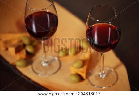 Wineglasses With Red Wine On Wood With Cheese And Green Olives - For Cozy Home Evening