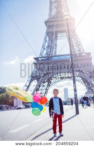 Cute boy on board of sailing yacht on summer cruise. Travel adventure, yachting with child on family vacation. Kid clothing in sailor style, nautical fashion.