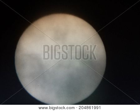 the sun viewed through a solar filter in a telescope with sunspot visible