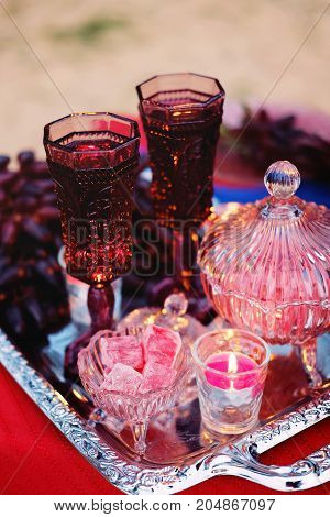 Dinner for two. Romantic table setting for a couple of lovers with glasses of red wine grapes candies and candlelight.