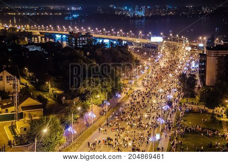 Aerial view to Stepan Razin Street in Voronezh, Russia. Crowd of people are walking along streets to look at firework at festival
