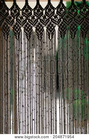 White macrame curtain made with rope. Handmade craftwork.