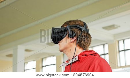 Teenager in VR headset enjoying virtual reality digital game. Virtual and augmented reality are increasingly used in human lives.