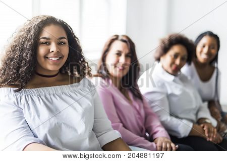 Two family Friends Sitting On Sofa Together having fun