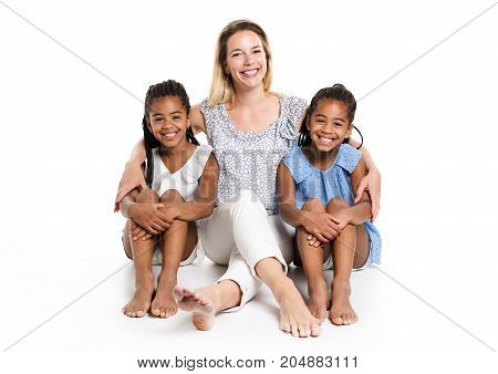Two Afro twin child posing on a white background studio with white mother