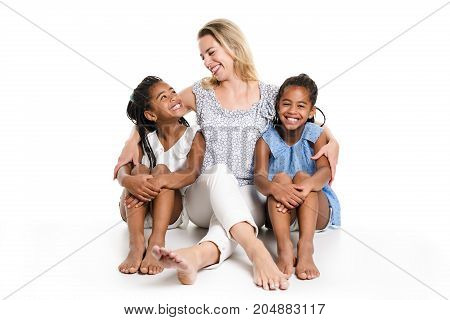 Two Afro twin child posing on a white background studio with white mother
