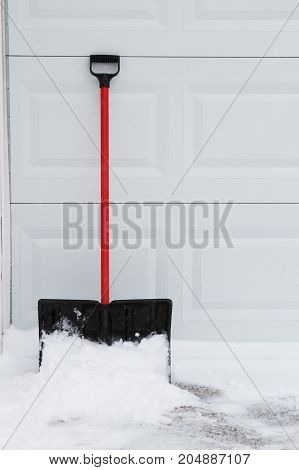 a snow shovel leaning on garage door.